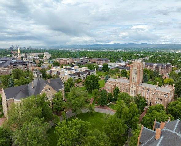 Aerial view of DU campus with the Rocky Mountains and Denver skyline in the background